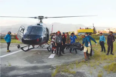  ??  ?? Volunteers and friends carry the dead bodies of Korean and Nepali climbers recovered from Mount Gurja after being airlifted to Teaching Hospital in Kathmandu yesterday.