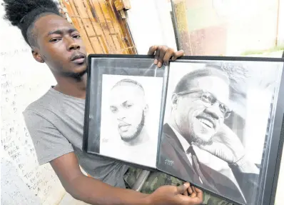  ?? RUDOLPH BROWN/PHOTOGRAPH­ER ?? Twenty-three-year-old artist Kadeen Christie shows of two of his pencil portraits. The resident of Manchester Lane in Spanish Town, St Catherine, is calling on Jamaicans to make a greater effort to embrace local artists.