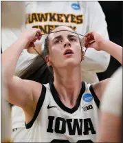  ?? AP PHOTO/MATTHEW PUTNEY ?? Iowa guard Caitlin Clark (22) adjusts a headband during a timeout in the first half of a first-round college basketball game against Holy Cross in the NCAA Tournament, Saturday, March 23, 2024, in Iowa City, Iowa.