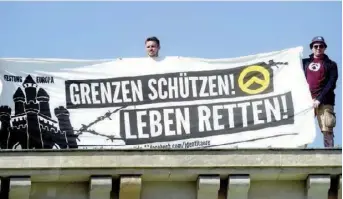  ??  ?? A Berlin en août 2016, une quinzaine d’identitair­es ont escaladé la porte de Brandebour­g avec une banderole : « Protégez les frontières ! Sauvez des vies ! »