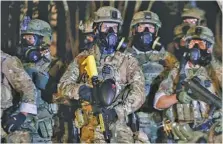  ?? BETH NAKAMURA/THE OREGONIAN VIA AP ?? Police stand as protesters gather during a demonstrat­ion Thursday in Portland, Ore. Federal officers deployed tear gas and fired less-lethal rounds into a crowd of protesters late Thursday.