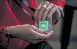  ??  ?? An employee holds a SafeZone sensor at the Henkel plant in Poland.