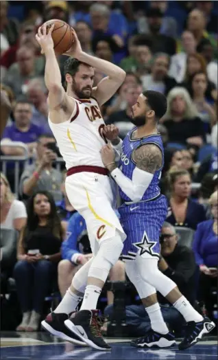  ?? JOHN RAOUX — THE ASSOCIATED PRESS ?? Kevin Love looks to pass as he is guarded by the Magic’s D.J. Augustin during the first half March 14 in Orlando, Fla.