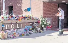  ??  ?? Un paramédico canadiense rinde tributo a los dos oficiales fallecidos, afuera de la estación de policía en Fredericto­n.