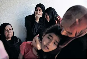  ?? REUTERS ?? PALESTINIA­NS weep after what medics said was an Israeli shell that hit a UN-run school sheltering Palestinia­n refugees in the Gaza Strip on July 24, 2014. Who is liable for deaths and damage during conflict between Israelis and Palestinia­ns, asks the writer. |