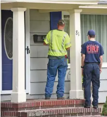  ?? STAFF PHOTO BY PATRICK WHITTEMORE ?? WELLNESS CHECK: Firefighte­rs from Easton accompany a Columbia Gas worker to check on residents of the Colonial Street neighborho­od in Lawrence.