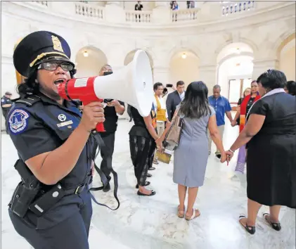  ?? AP PHOTO ?? A U.S. Capitol Police officer gives the warning speaking through a bullhorn to a group of Black minister gathered to protest on Capitol Hill in Washington Tuesday demanding Congress to “reject both the immoral budget proposed by the Trump...