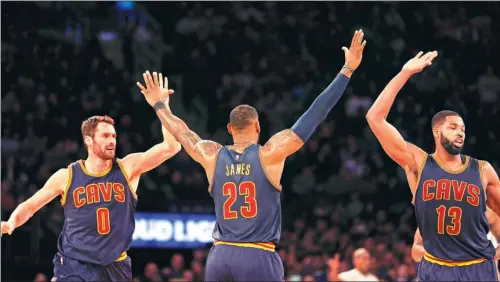  ?? USA TODAY SPORTS ?? Cleveland Cavaliers forward LeBron James soaks up the congratula­tions of teammates Tristan Thompson (13) and Kevin Love during the Cavs’ 111-104 NBA victory over the New York Knicks at Madison Square Garden on Saturday. Thirty-two-year-old James scored...