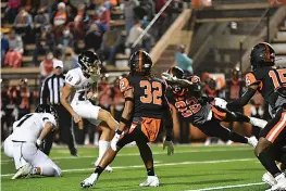  ?? Photo by Kevin Sutton ?? ■ Texas High defender Lajontae Wrightner (22) attempts to block a field goal attempt by Lake Creek’s Landon Bussell with fellow Tigers Michael Thomas (32) and Marcell Beaver (15) defending during a Class 5A, Division II football game Friday at Tiger Stadium in Grim Park.