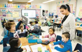  ?? JULIA NIKHINSON/AP ?? Bowie State University graduate Christine Ramroop teaches first graders at Whitehall Elementary School in Bowie, Maryland.