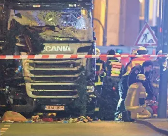  ?? PAUL ZINKEN, EUROPEAN PRESSPHOTO AGENCY ?? Rescue workers assess the scene near the Kaiser Wilhelm memorial church in Berlin, where a truck attack shattered the pre-Christmas calm in Germany.