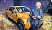  ?? CARLOS OSORIO/AP ?? Kumar Galhotra, Ford’s President of Americas and Internatio­nal Markets Group, poses with the Maverick compact pickup Jan. 11 in Detroit.