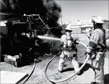  ?? LOANED PHOTO/YUMA FIRE DEPARTMENT ?? WITH THE CLOSEST HYDRANT OVER A BLOCK AWAY, City of Yuma firefighte­rs had to lay several hundred feet of water supply line Thursday morning to put out a motorhome fire in the 1100 block of South Myrtle Avenue.