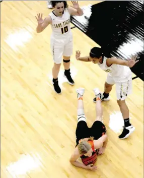  ?? PHOTOS BY MARK HUMPHREY ENTERPRISE-LEADER ?? Gravette senior Jessica Bookout crashes to the hardwood after being jostled by Prairie Grove seniors Lexie Madewell (left) and Larisha Crawford during a struggle over possession of a loose ball. Gravette emerged from the 4A-1 girls basketball showdown victorious by a 48-40 score over the Lady Tigers on Jan. 8.