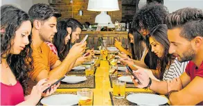  ??  ?? Is our obsession with mobiles killing off conversati­on at the dinner table?