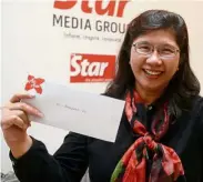  ??  ?? Delighted mum: Lau is all smiles as she holds up the AirAsia X flight tickets.