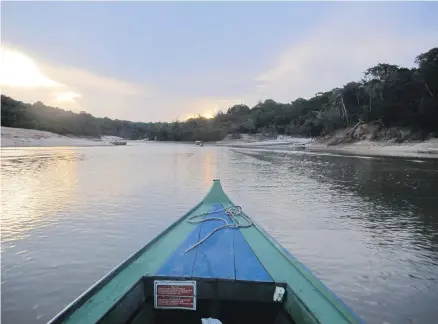  ??  ?? A sunset in the Amazon rainforest is seen from a tributary of the Rio Negro outside Manaus, Brazil. Boat travel is common throughout the Amazon basin, both for forest dwellers and tourists.