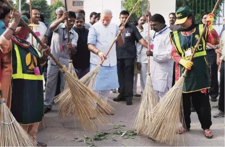  ?? FILE PHOTO: PTI ?? CLEAN SWEEP: Prime Minister Narendra Modi at a clean-up drive in Valmiki Basti, New Delhi, on October 2, 2014