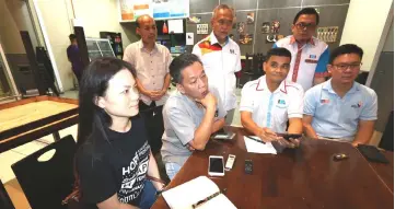  ??  ?? Wong (seated second left) speaks to the press at the airport prior to the arrival of the eight Sarawakian­s. With him are (seated, from left) Lau, Chen and Ling.