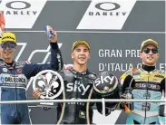  ??  ?? TOP SPOT: Andrea Migno, centre, on the podium with Del Conca Gresini rider, Italian Fabio Di Giannanton­io, left, who finished second, and RBA BOE Racing Team rider, Spaniard Juanfran Guevara, who finished third in Moto3