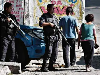  ?? Fabiano Rocha/Agência O Globo ?? Policiais militares patrulham entrada da favela Cidade Alta, que foi alvo de conflito