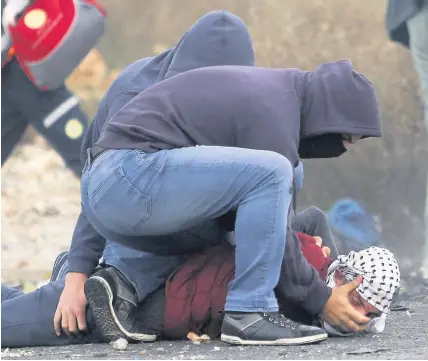  ?? Nasser Shiyoukhi ?? > Undercover Israeli police arrest a Palestinia­n demonstrat­or during clashes following protests against Donald Trump’s decision to recognise Jerusalem as the capital of Israel, in the West Bank city of Ramallah