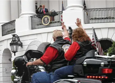  ?? Alex Wong / Getty Images ?? President Donald Trump watches as bikers roll by the White House on Friday during the Rolling to Remember Ceremony: Honoring Our Nation’s Veterans and POW/MIA.