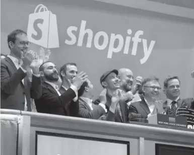  ?? RICHARD DREW/THE ASSOCIATED PRESS ?? Shopify CEO Tobias Lutke, centre in a hat, rings the NYSE’s opening bell on May 21, marking the Canadian company’s IPO.