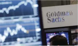  ?? —AP ?? NEW YORK: In this Oct 16, 2014 file photo, a screen at a trading post on the floor of the New York Stock Exchange is juxtaposed with the Goldman Sachs booth. Goldman Sachs, the most Wall Street of Wall Street firms, is pushing quietly into the realm of...