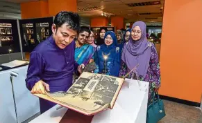  ??  ?? Universiti Malaya (UM) alumni ambassador Datuk Aznil Nawawi flips through an archival exhibit at the One Thousand Million Smiles show which pays tribute to the late pop star Sudirman at the UM library. — Bernama