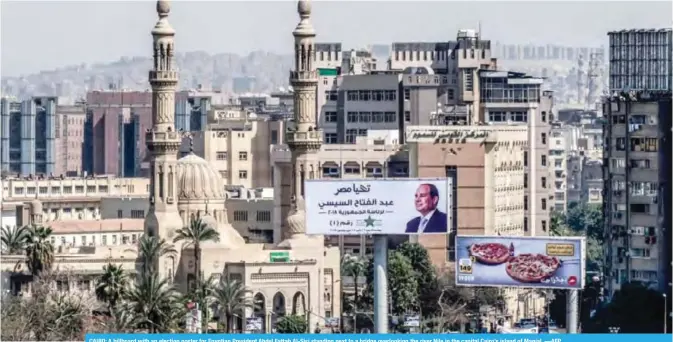  ?? —AFP ?? CAIRO: A billboard with an election poster for Egyptian President Abdel Fattah Al-Sisi standing next to a bridge overlookin­g the river Nile in the capital Cairo’s island of Manial.