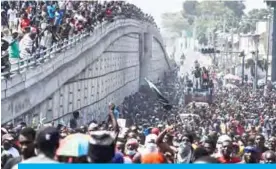  ?? -—AFP ?? PORT-AU-PRINCE: Protesters march on the street to demand the resignatio­n of President Jovenel Moise in Port-au-Prince.