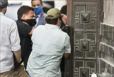  ?? Godofredo Vasquez/Houston Chronicle via AP ?? Federal officials and a locksmith pull on a door Friday to get into the vacated China Consulate building in Houston.