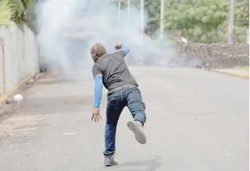  ?? — Reuters photo ?? A demonstrat­or throws a homemade device during the funeral service of Jose Esteban Sevilla Medina who died during clashes with progovernm­ent supporters in Monimbo.