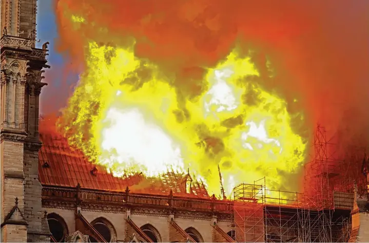  ??  ?? Out of control: Smoke and flames billow from Notre Dame as the fire sweeps through the historic cathedral – much of the roof collapsed just after 8pm local time