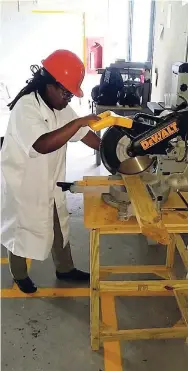  ??  ?? Carpenter Claudia Chambers operates a circular saw.