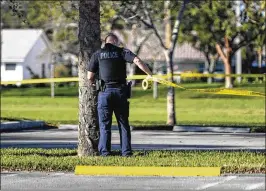  ?? BRUCE R. BENNETT / THE PALM BEACH POST ?? A police officer puts up yellow tape at Betti Stradling Park in Coral Springs on Wednesday for family members of students at Marjory Stoneman Douglas High School in Parkland. Students were bused to the park, which sits near Coral Springs Middle School, after the mass shooting at the high school.