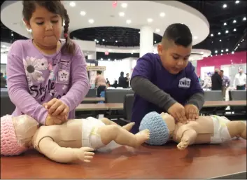  ?? PHOTO ANDY VELEZ ?? Six-year-old Analiah Ruiz (left) and her cousin Joseph Encinas, 5, practice CPR at El Centro Regional Medical Center’s Baby and Children’s Expo Saturday at Imperial Valley Mall.