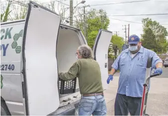  ?? BY MARCO SANCHEZ — PEC ?? Ken Smith (right) of Cool Lawn Farm in Remington helps Andy Platt of Rappahanno­ck Food Pantry load up with milk.