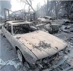  ??  ?? Remains of luxury cars ravaged by flames outside home in Malibu