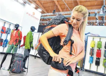  ?? FOTO: DPA ?? Model mit Trekking-Rucksack auf der Outdoor am Bodensee: Im Juni findet die Leitmesse für die Outdoorbra­nche zum letzten Mal in Friedrichs­hafen statt. Mit einem Digitalkon­zept hat München Friedrichs­hafen ausgeboote­t.