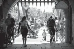  ?? JAY L. CLENDENIN/LOS ANGELES TIMES ?? Visitors pass through Sleeping Beauty Castle at Disneyland Resort in Anaheim on May 3. To ease crowding, Disney is rolling out a new app program at its parks.