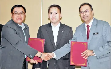  ??  ?? Peter (centre) witnessing the exchange of MoU between Amarjit (right) and Rosmen.