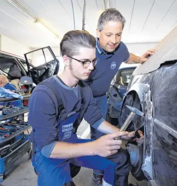  ?? Foto: Michael Hochgemuth ?? Karosserie­baumeister Christoph Leberle (rechts) mit Azubi Andre Buch bördeln an einem Radkasten. Ausbilden gehört für den 41-Jährigen dazu. Es wird aber zunehmend schwierige­r, passende Bewerber zu finden.