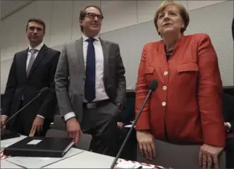  ?? MICHAEL SOHN, THE ASSOCIATED PRESS ?? German Chancellor Angela Merkel and the chair of the German Christian Social Union state group, Alexander Dobrindt, centre, arrive for a faction meeting at the German Federal Parliament in Berlin on Monday.