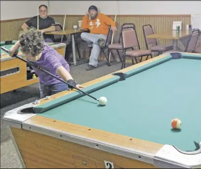  ??  ?? Nine-year-old Zander Block takes aim during the pool tournament, held to raise funds for the area Chained Eagles organizati­on's projects.