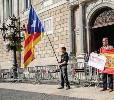  ??  ?? Barcelona, maandagmor­gen, bij het paleis van de Catalaanse regering: links een jonge voorstande­r van Catalaanse onafhankel­ijkheid, rechts Spaanse nationalis­ten.