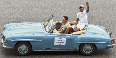  ??  ?? Making waves: Mercedes’ Lewis Hamilton waving to the fans as he is driven around in a classic car before the Malaysia Formula 1 Grand Prix race at Sepang on Sunday. — Bernama