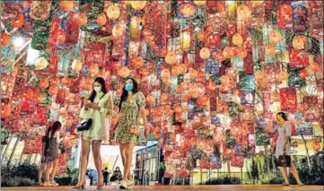  ?? AFP ?? People walk under festive decoration­s for the upcoming Lunar New Year outside a shopping mall in Bangkok, Thailand.