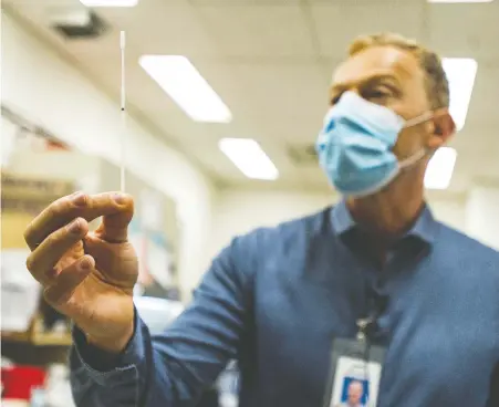  ?? JASON PAYNE ?? St. Paul's Hospital is one of the main centres in B.C. for testing for COVID-19 through their medical microbiolo­gy and biology labs. Pictured is Dr. Marc Romney, medical leader, medical microbiolo­gy and virology, with a swab used to test for COVID-19.